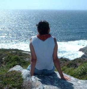 Frau auf einem Fels am Meer